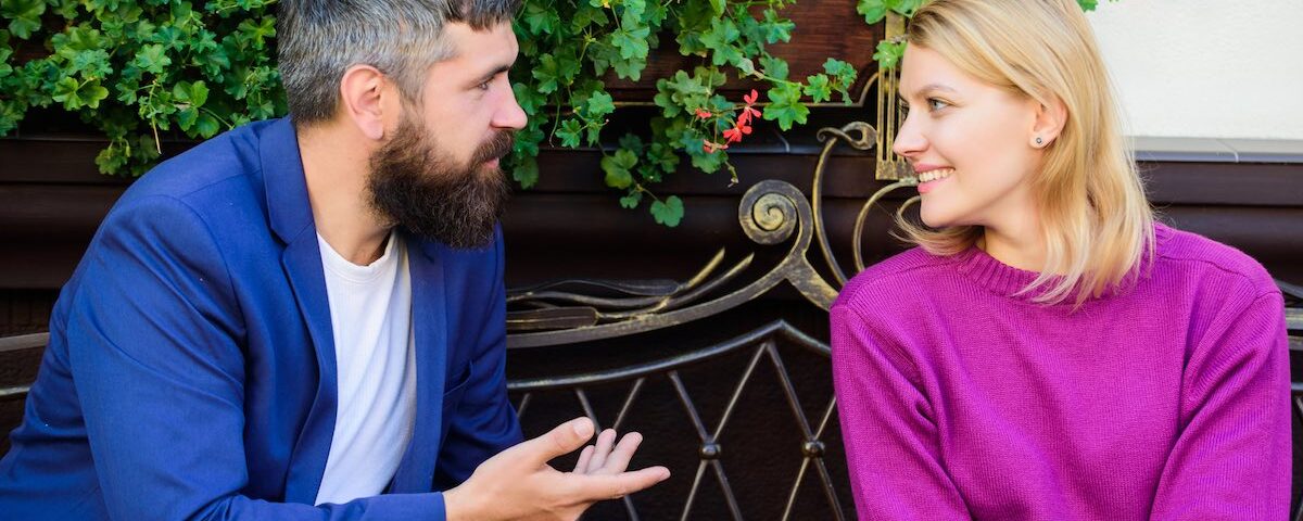 Ragazza che sorride a un ragazzo durante un primo approccio in un bar